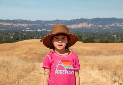 Portrait of smiling girl standing on field