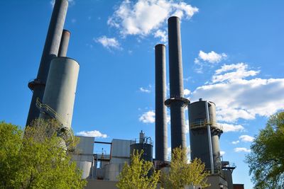 Low angle view of factory against blue sky