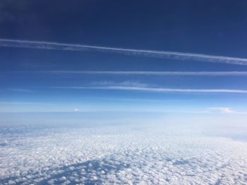Scenic view of cloudscape and vapor trails in sky