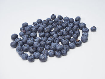 High angle view of black berries over white background