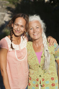 Portrait of adult daughter and mother in garden