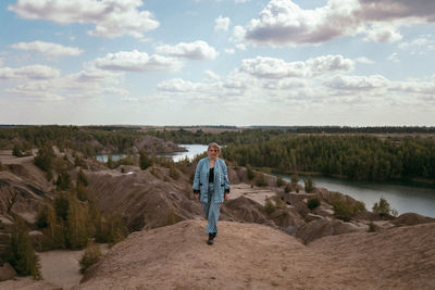 Rear view of woman walking on mountain against sky