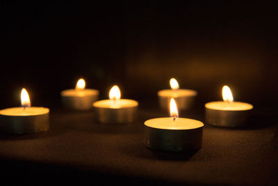 Close-up of illuminated candles on table