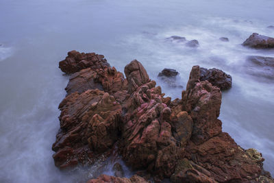 Scenic view of rocks in sea against sky
