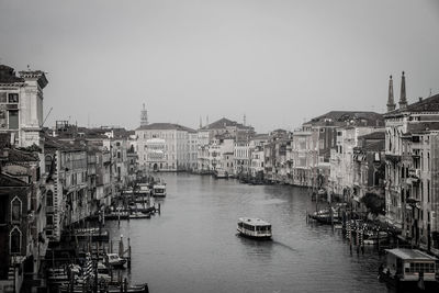 Boats in river with city in background