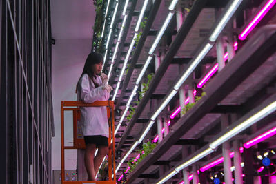 Dominique alexandra looking at her indoor plants with the controlled environment agriculture system