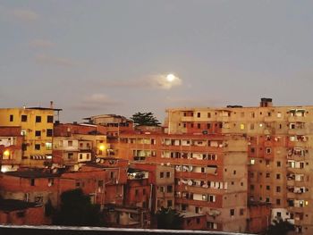 Buildings in city against sky at sunset