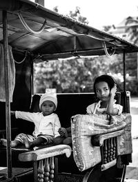 Full length of siblings sitting outdoors