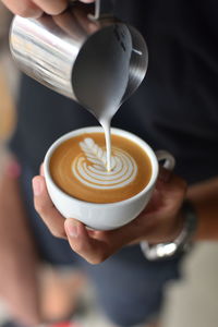 Close-up of cappuccino holding coffee cup