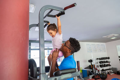 Dad teaching daughter to do pull ups