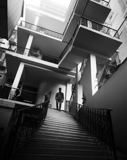 Low angle view staircase waking man black and white