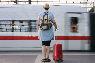 Rear view of man walking on railroad station