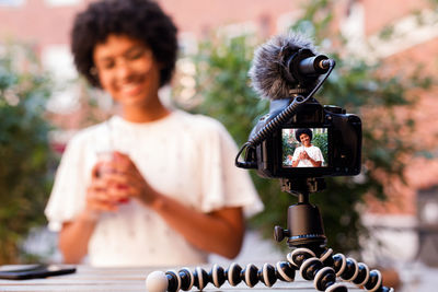 Teenage girl vlogging while sitting outdoors