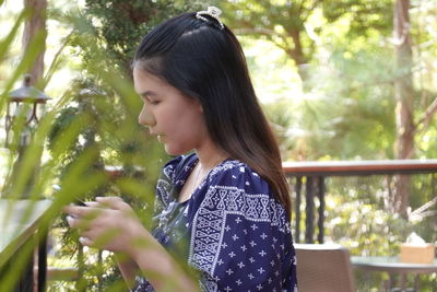 Side view of woman looking at trees