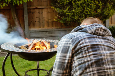 Rear view of man on barbecue grill