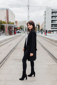 Portrait of young woman standing in city