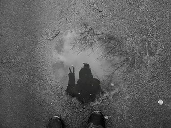 Low section of people standing on puddle