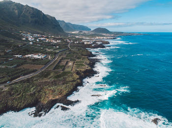 Scenic view of sea and mountains against sky