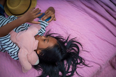 High angle view of woman sleeping on bed