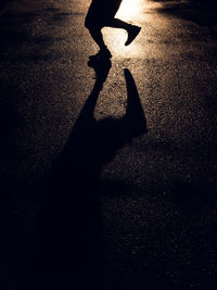 Low section of silhouette person on road