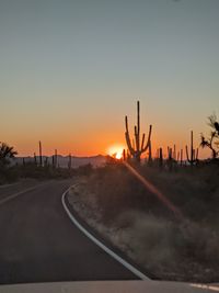 Silhouette road against sky during sunset