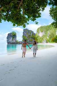 Rear view of woman walking at beach