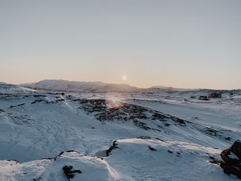 Scenic view of snow covered landscape against sky during sunset