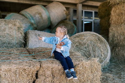 Full length of young woman standing on hay