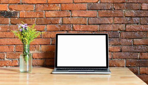Potted plant on table against wall