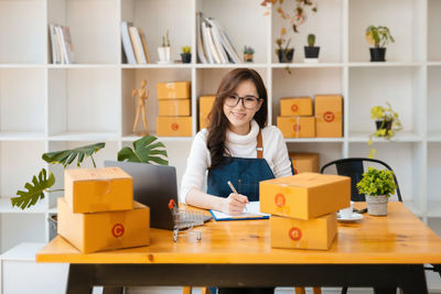 Young woman using laptop while sitting on table