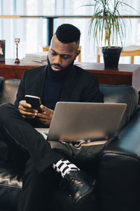Businessman using smart phone while working in office