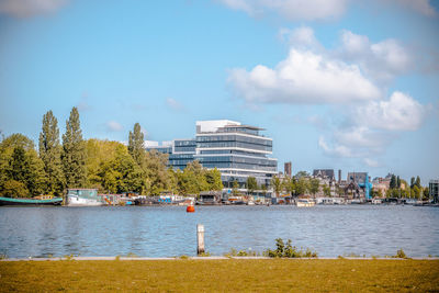 River by buildings against sky