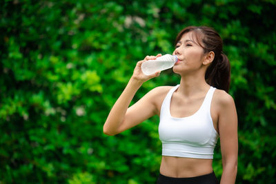 Young woman holding ice cream standing outdoors