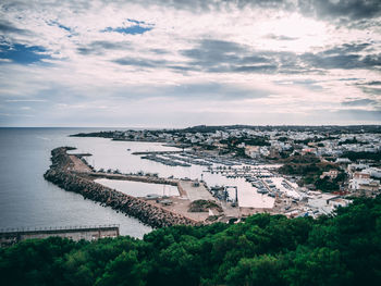 High angle view of cityscape by sea against sky