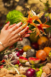 Cropped image of woman holding apple on plant