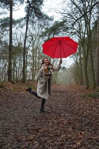 Rear view of woman with umbrella walking on park