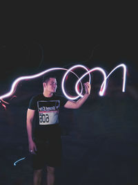 Full length of man standing in illuminated light