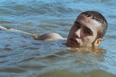 Portrait of young man swimming in sea