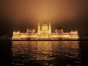 River with illuminated buildings in background at night