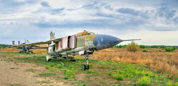 Abandoned airplane on field against sky