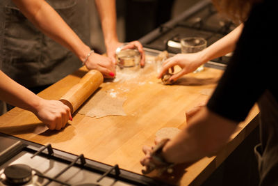 High angle view of people making cookies on kitchen counter