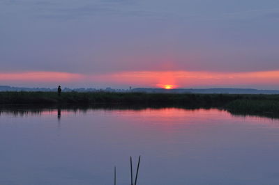 Scenic view of lake against romantic sky at sunset