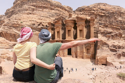 Rear view of woman standing against rock formations