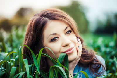 Close-up portrait of smiling young woman on field