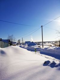 Snow covered landscape against clear blue sky