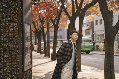 Man standing by street in city