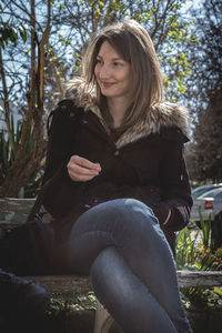 Beautiful young woman sitting in park