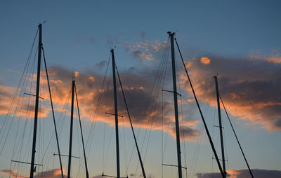 Low angle view of boat mast against sky during sunset