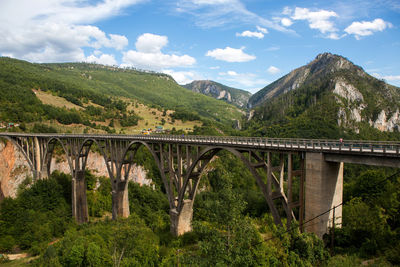 Bridge over mountains against sky