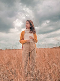 Woman standing on field against sky